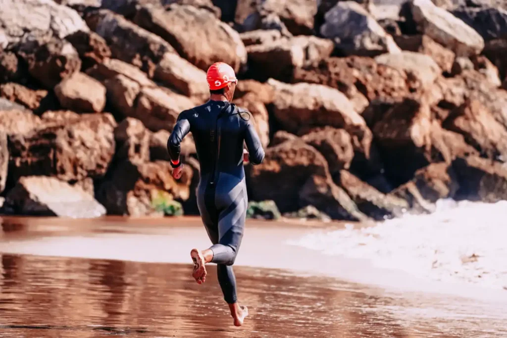 Triathlet läuft ins Wasser
